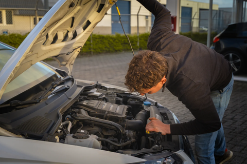 Inspectie van een auto onder de motorkap tijdens een aankoopkeuring